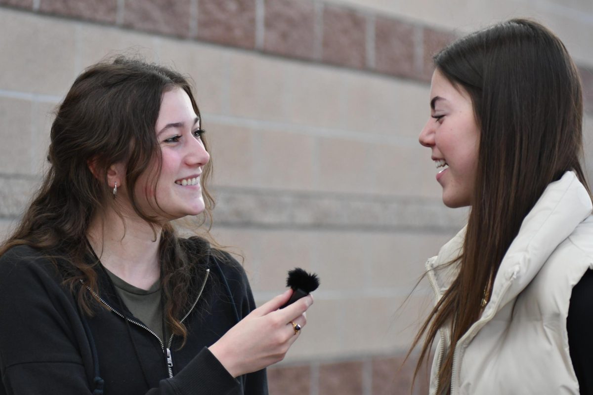 Greer Scholarship winner Claire Bauer
 holds up a mic as she interviews a student on the Super Bowl results Feb. 13. Bauer interviewed students to create a compilation of reaction interviews.